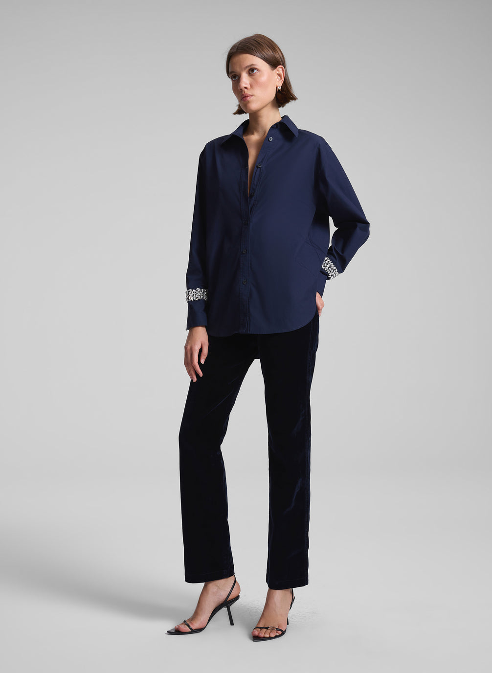 woman wearing navy embellished shirt and black pants
