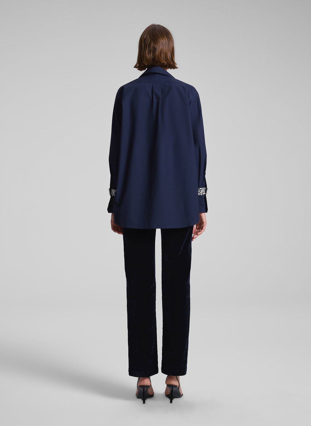 woman wearing navy embellished shirt and black pants
