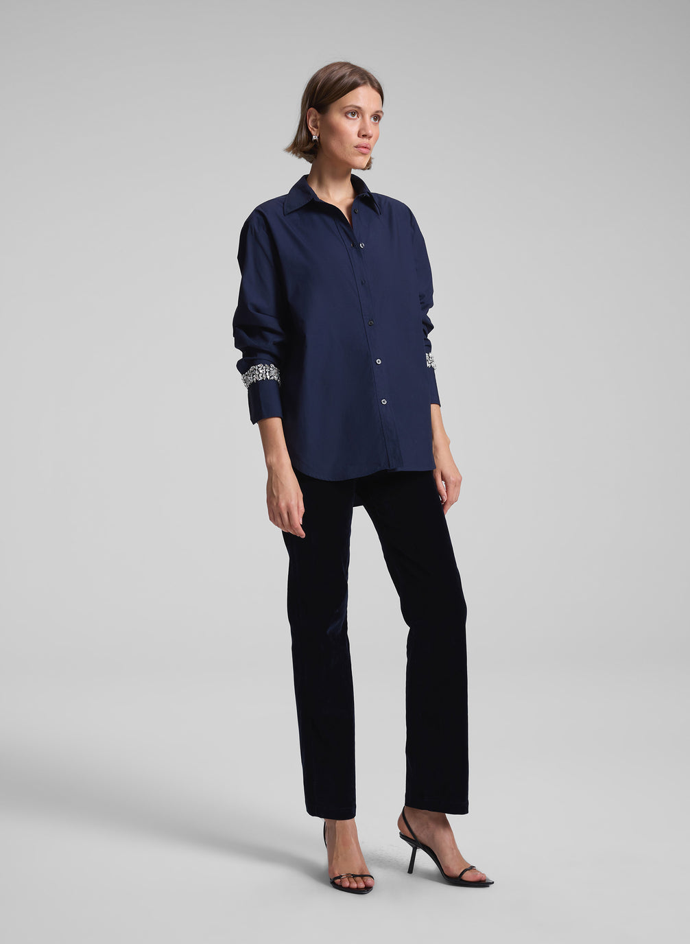 woman wearing navy embellished shirt and black pants
