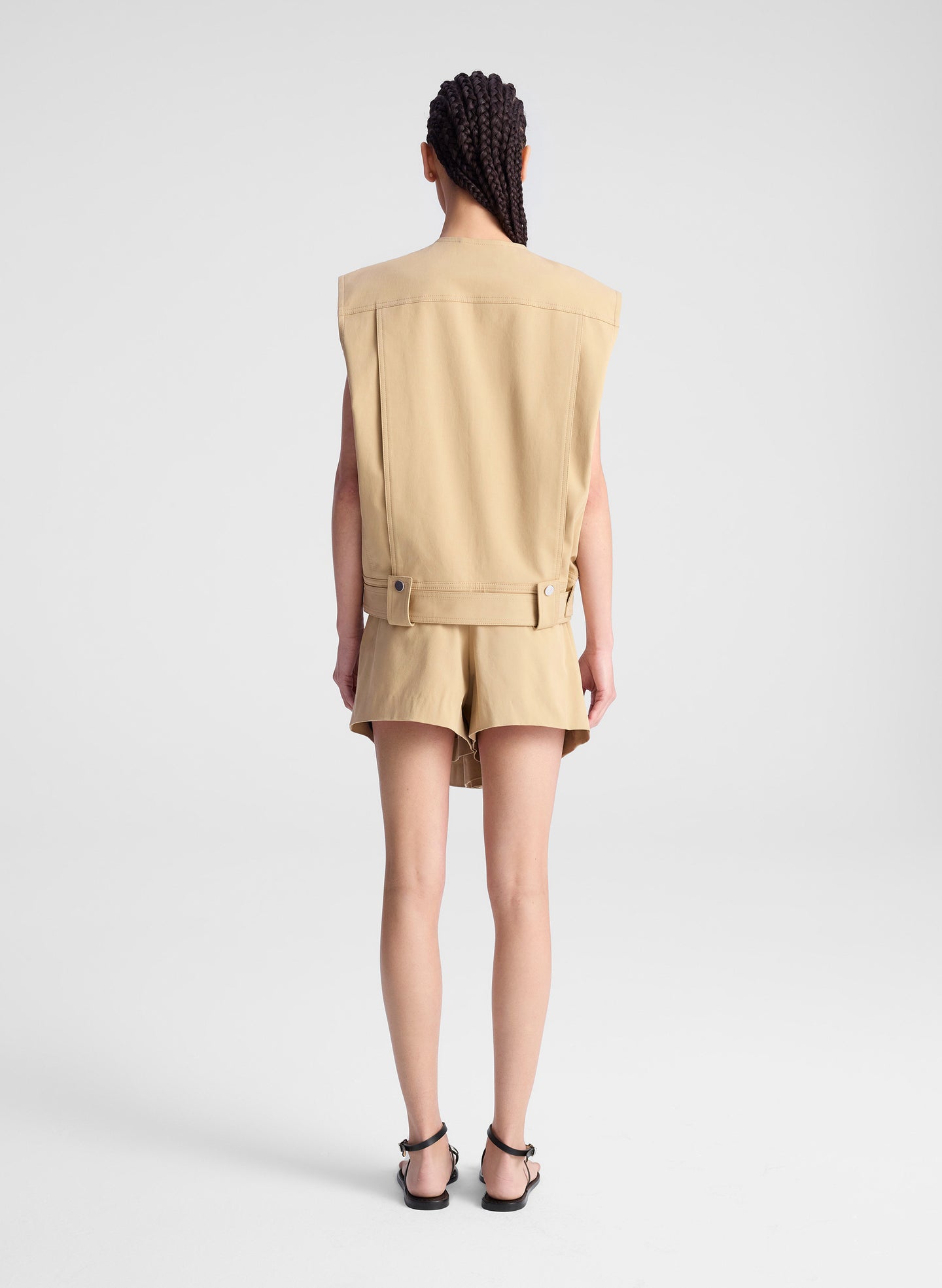 woman wearing beige sleeveless jacket and matching skort