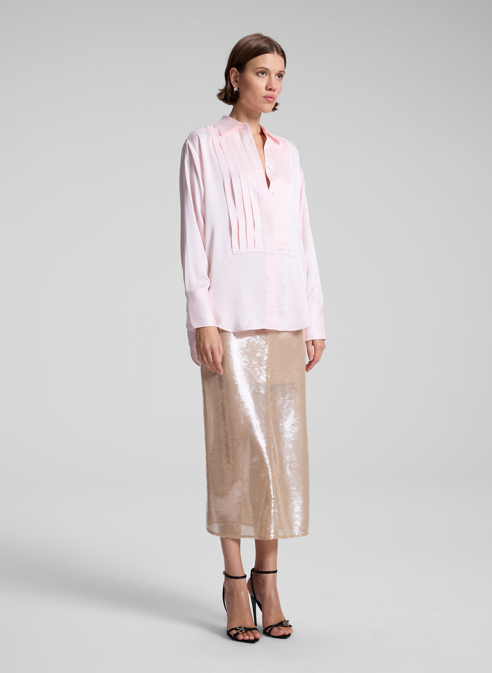 woman wearing pink shirt and sequined midi skirt