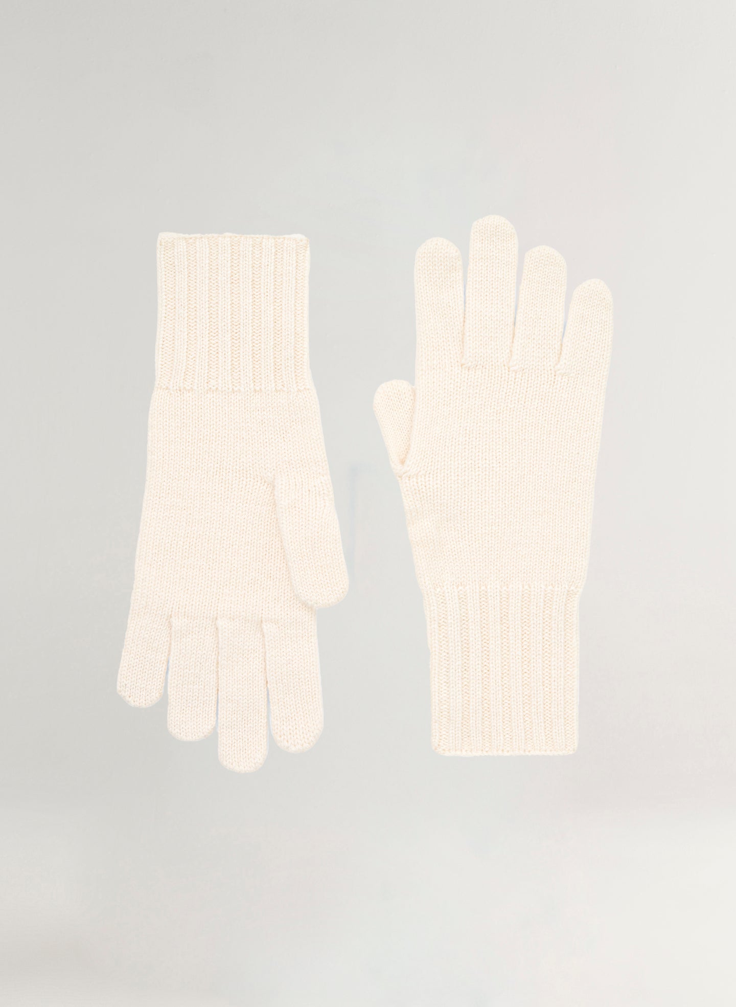 Pair of white gloves on a light gray background