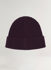 Dark purple ribbed knit beanie on a light gray background