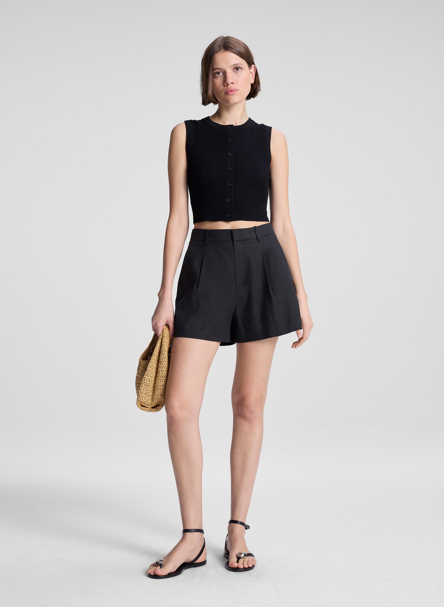 woman wearing black sleeveless top and black linen shorts