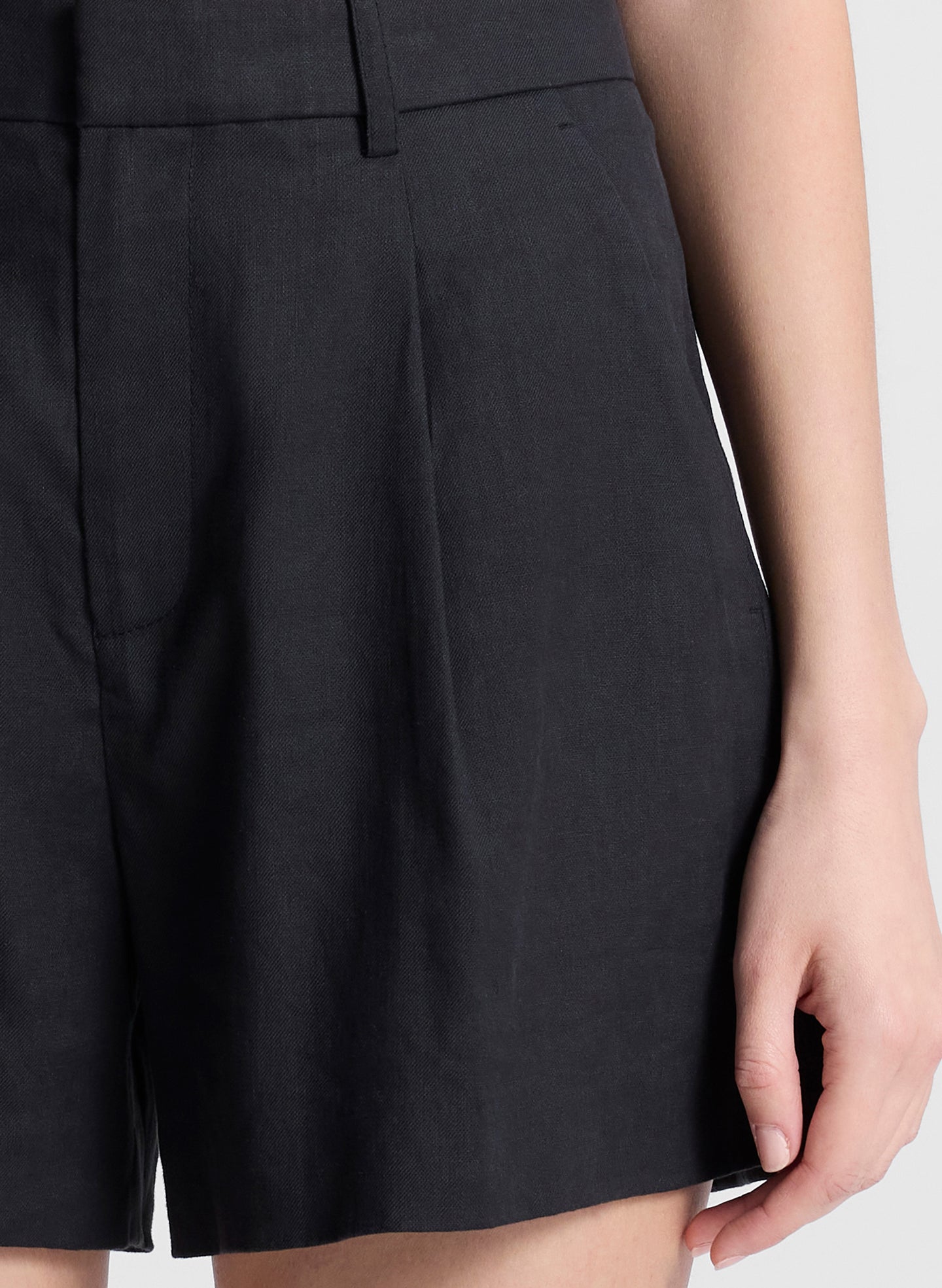 woman wearing black sleeveless top and black linen shorts