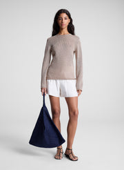 woman wearing tan sweater and white shorts