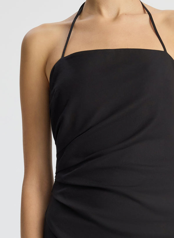 detail view of woman wearing black halter neckline ruched mini dress