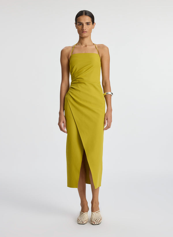 front view of woman wearing yellow halter neckline ruched midi dress