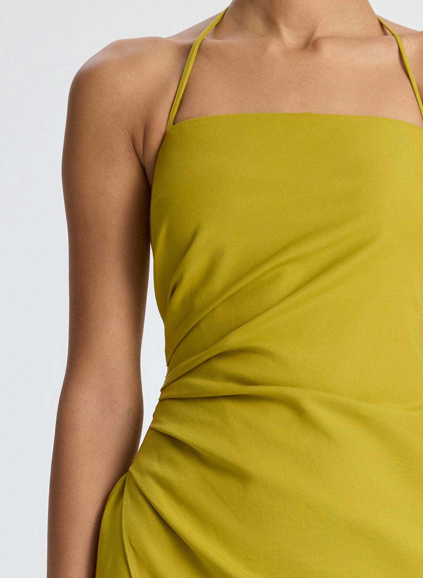 detail view of woman wearing yellow halter neckline ruched midi dress