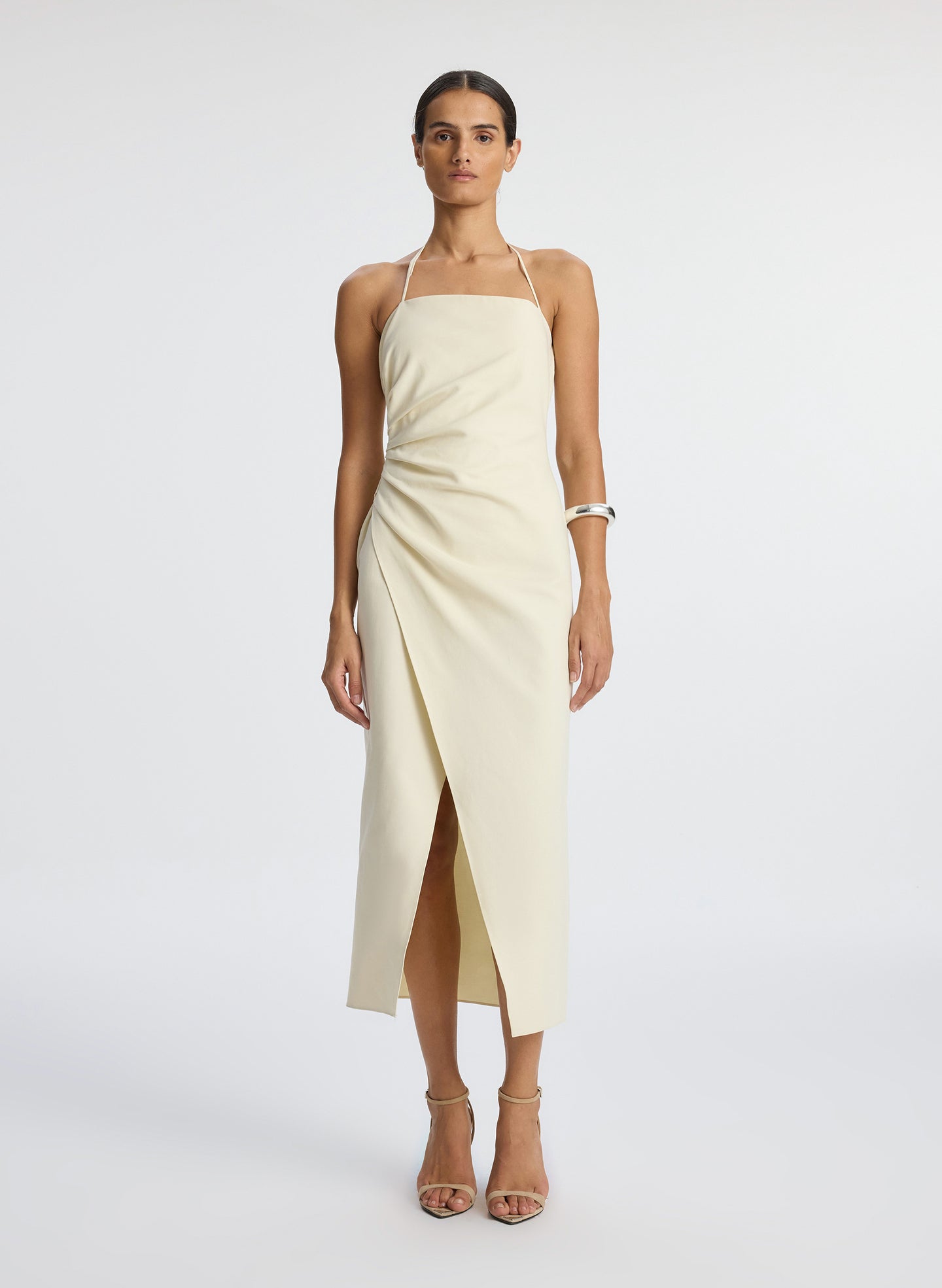 front view of woman wearing cream halter neckline ruched midi dress