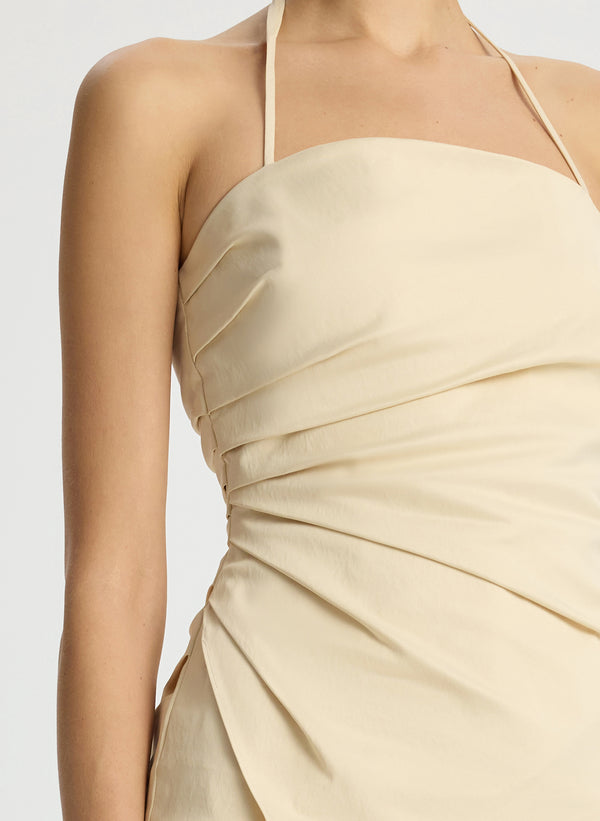 detail view of woman wearing beige halter top with side ruching and beige wide leg pant