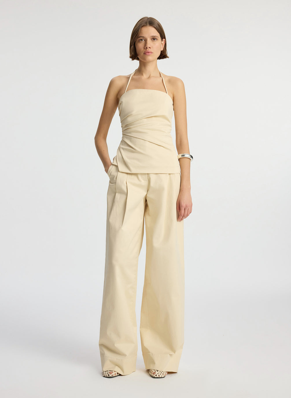 front  view of woman wearing beige halter top with side ruching and beige wide leg pant
