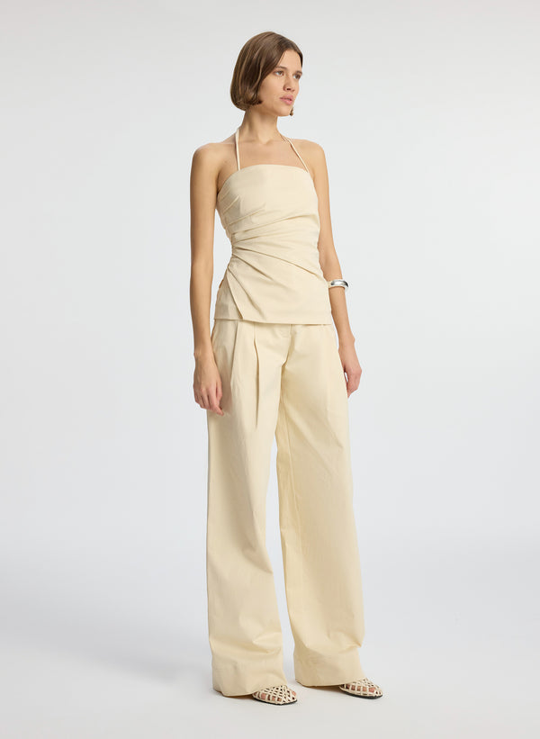 front view of woman wearing beige sateen halter top and matching sateen wide leg pants