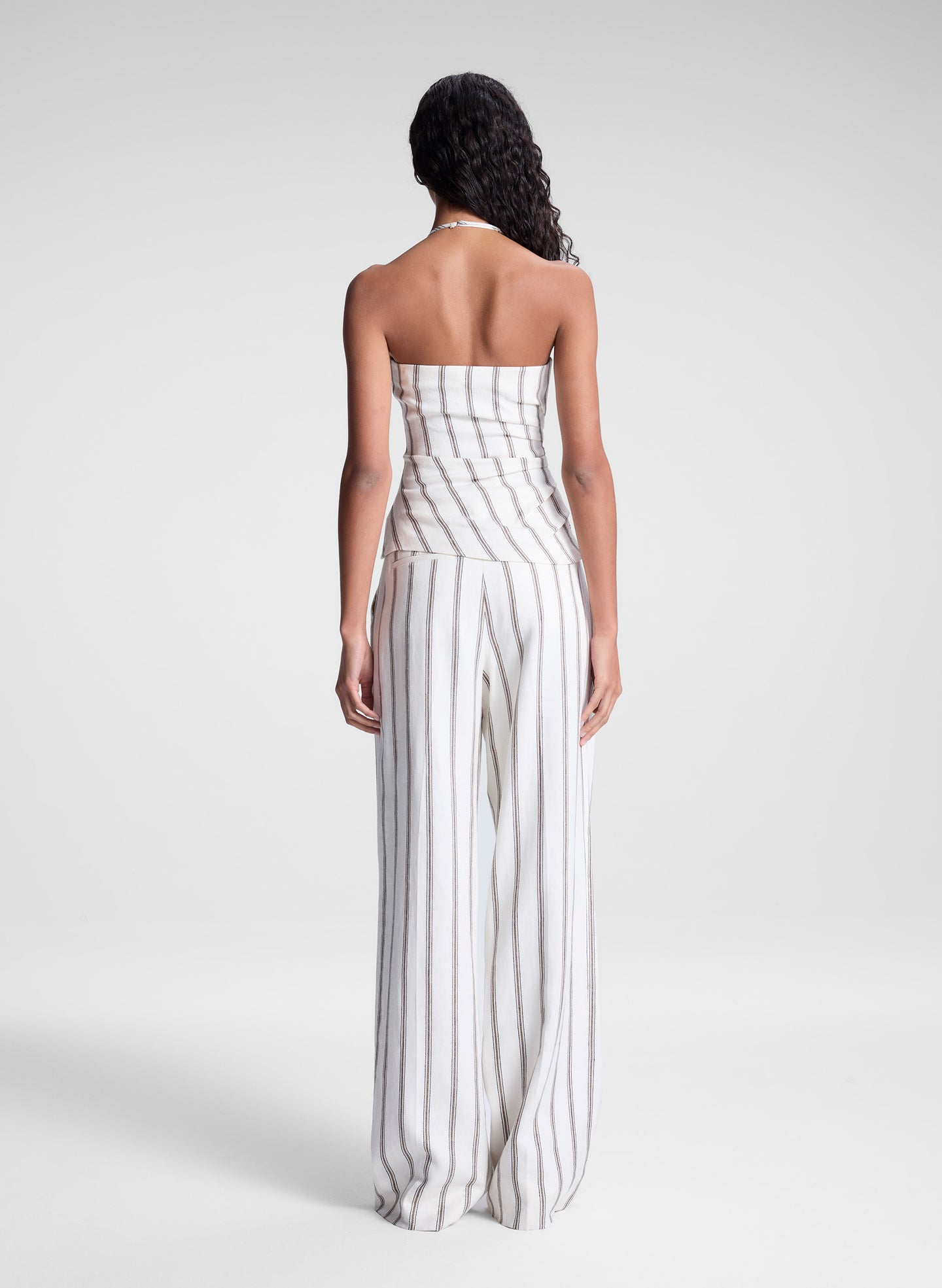 woman wearing striped halter top and matching striped pant set