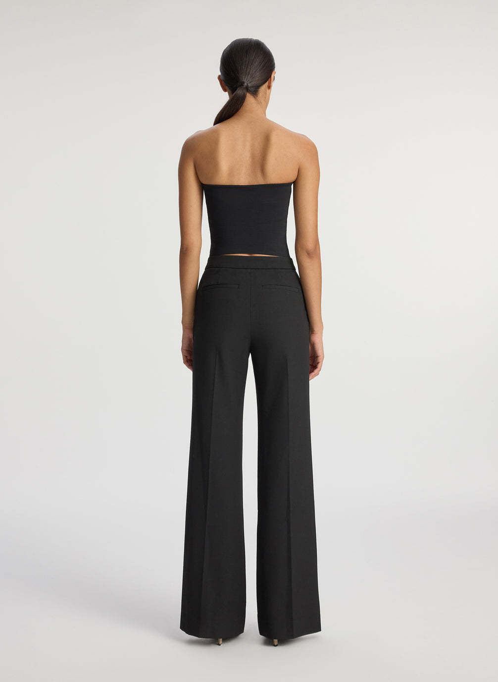 back view of woman wearing black strapless top and black pants