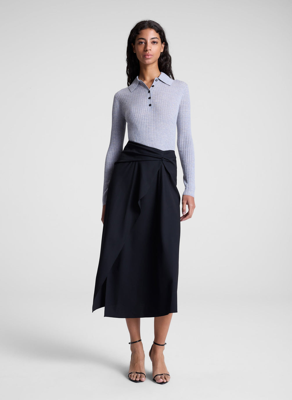 woman wearing grey collared top and black midi skirt