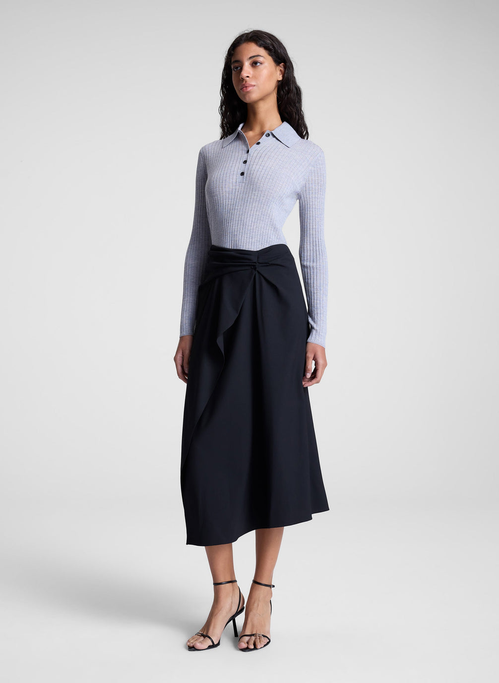 woman wearing grey collared top and black midi skirt