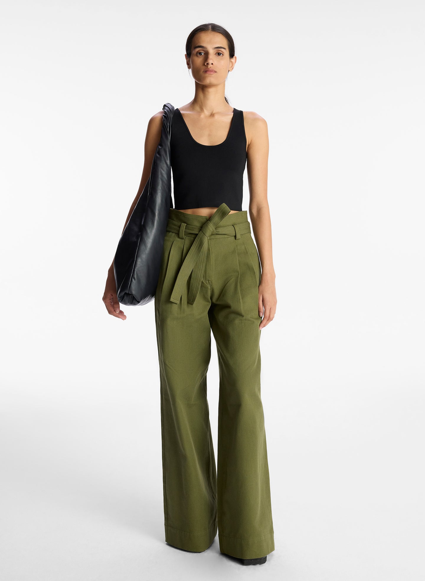 front view of woman wearing black tank top and olive green wide leg pants