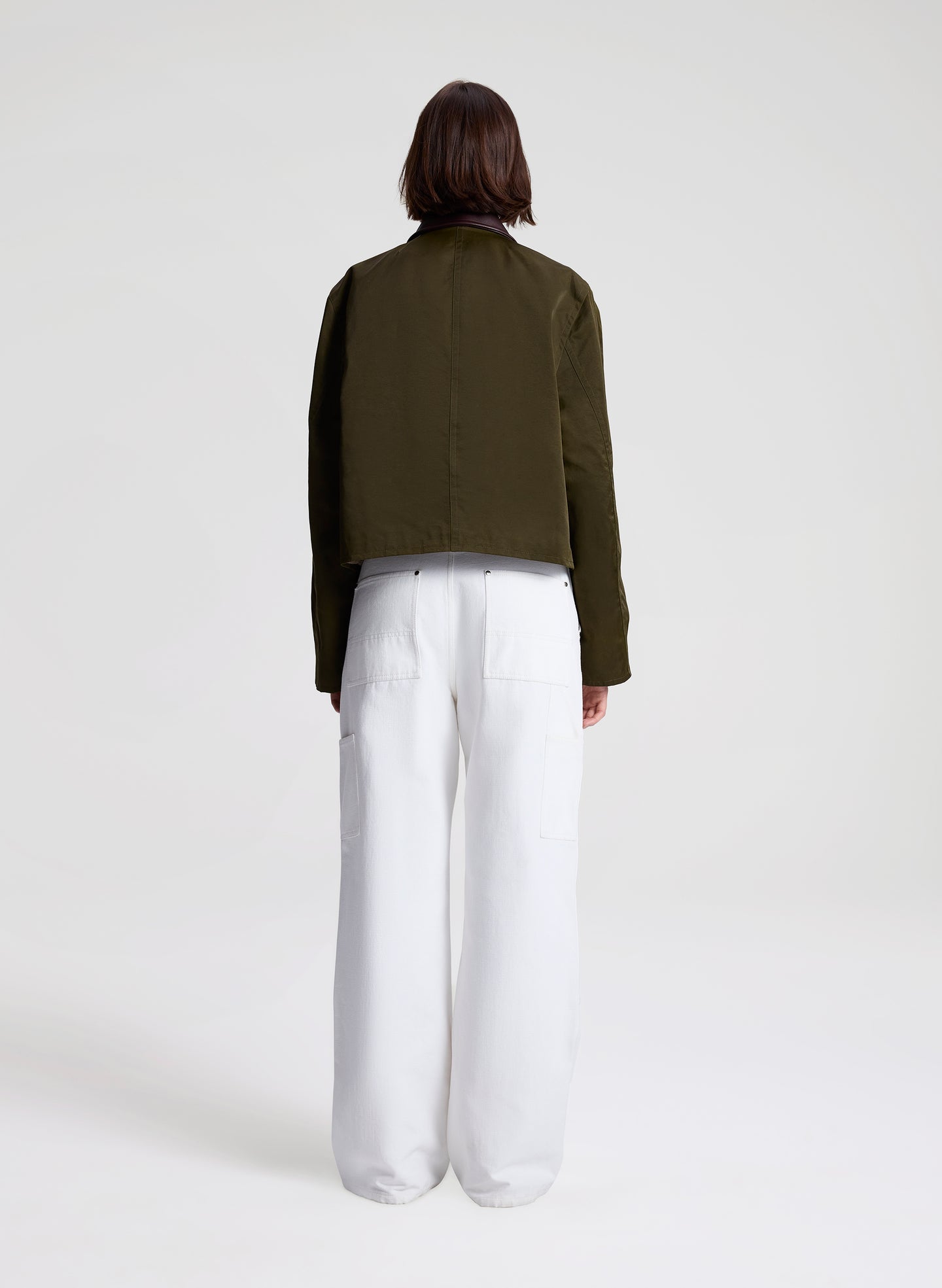 woman wearing green jacket and white top and pants