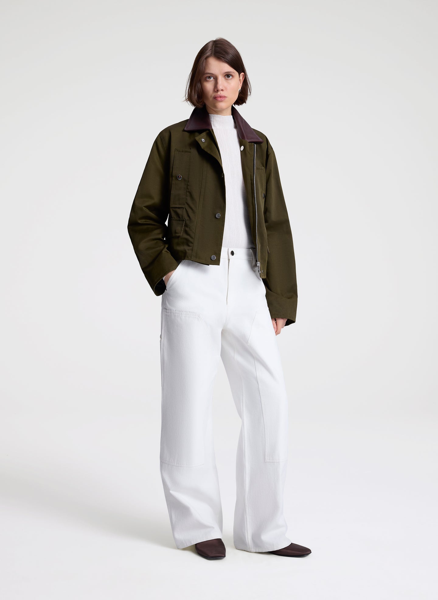 woman wearing green jacket and white top and pants
