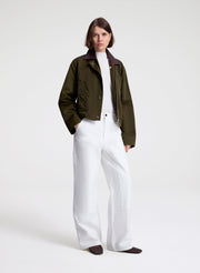 woman wearing green jacket and white top and pants