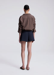 woman wearing brown striped shirt and navy blue skort