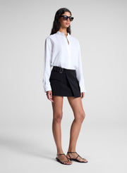 woman wearing white top and black mini skirt