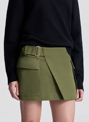 woman wearing black v neck sweater and olive green wrap mini skirt