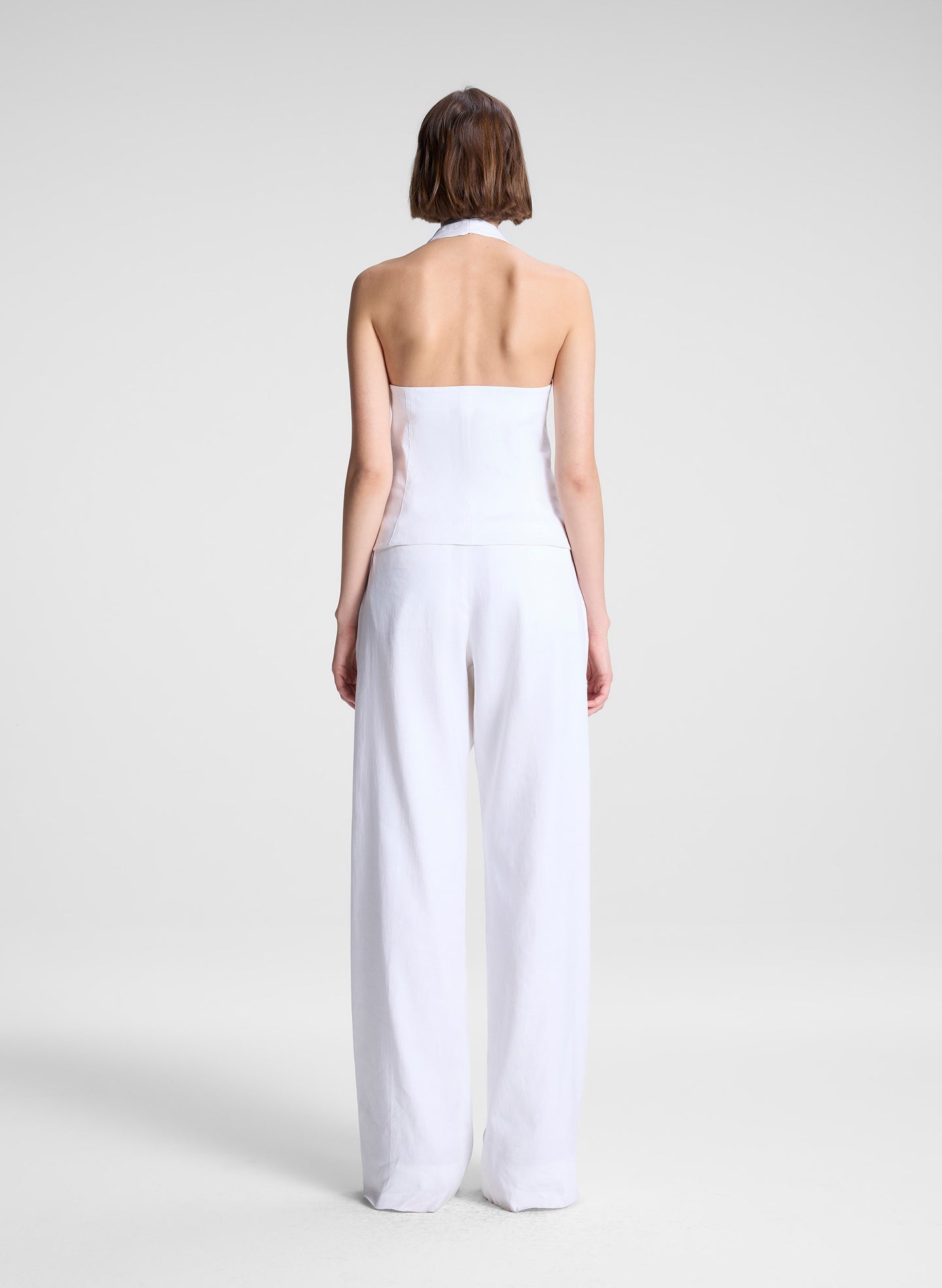 woman wearing white linen halter top and white linen pants