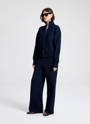 Person wearing a navy blue outfit on a white background