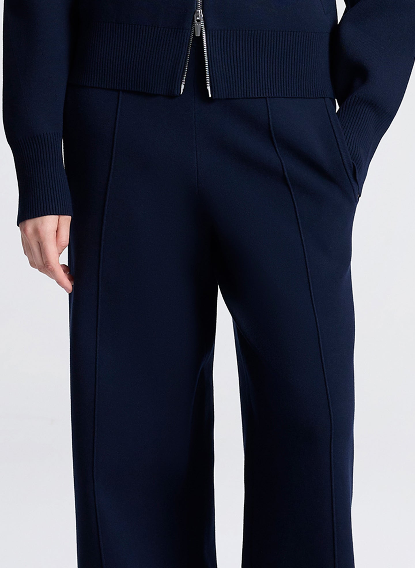 Navy blue pants worn by a person on a white background