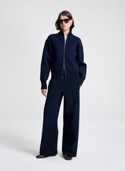 Person wearing a navy blue outfit on a white background