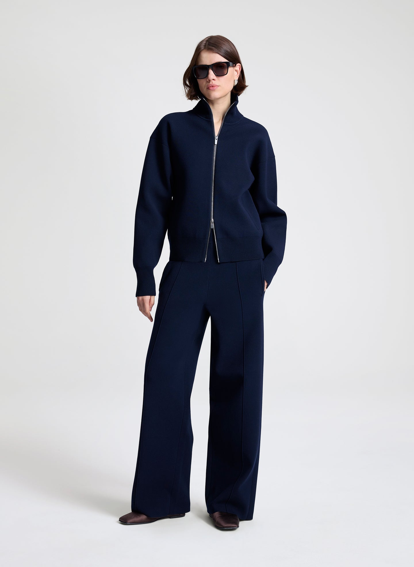 Person wearing a navy blue outfit on a white background