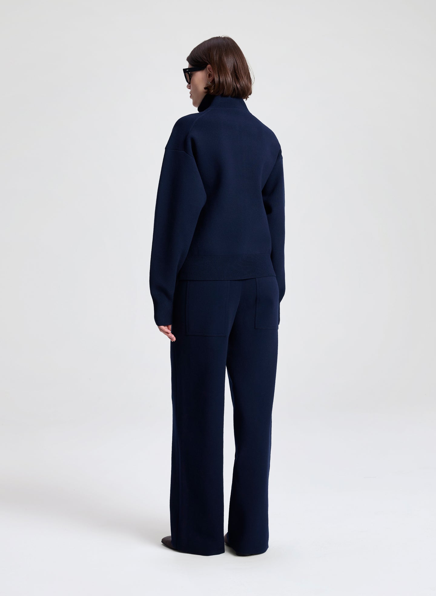 Person wearing a navy blue suit on a white background