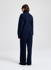 Person wearing a navy blue suit on a white background