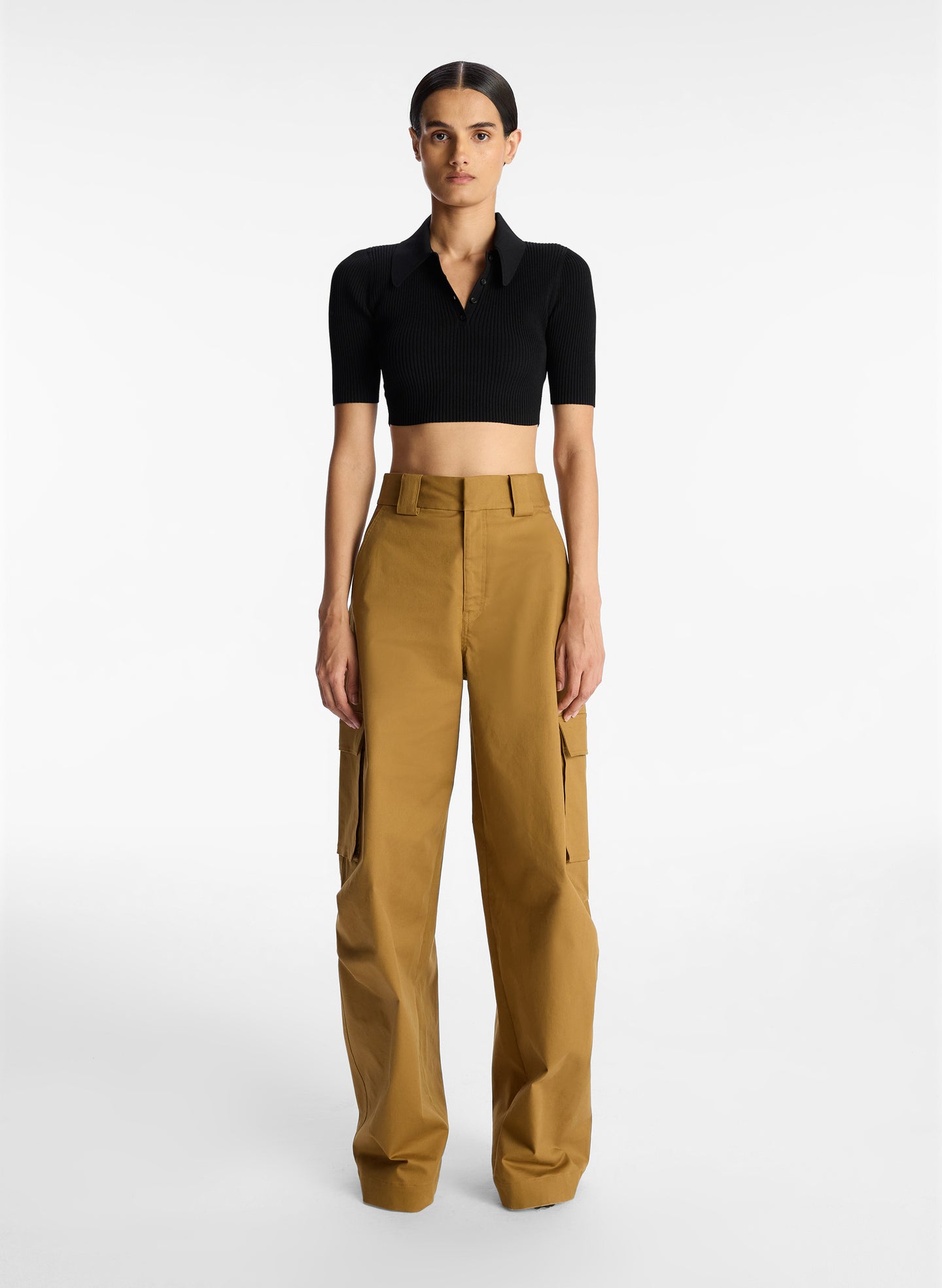 front view of woman wearing black cropped collared knit shirt and tan cargo pants
