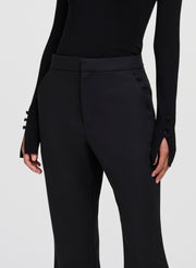 Black high-waisted trousers with a structured waistband and side buttons on the sleeves, shown on a model against a light gray background.