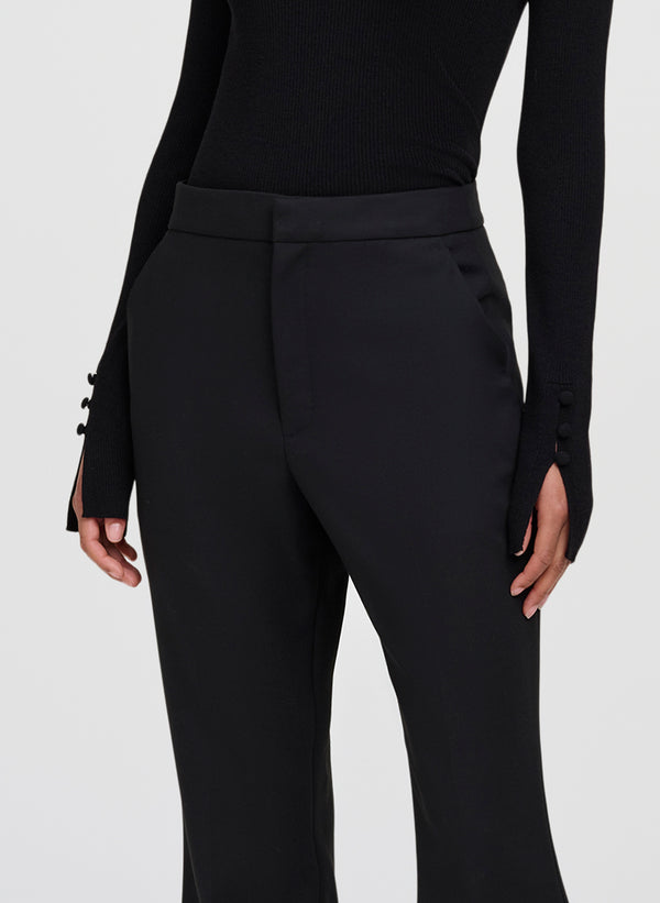 Black high-waisted trousers with a structured waistband and side buttons on the sleeves, shown on a model against a light gray background.