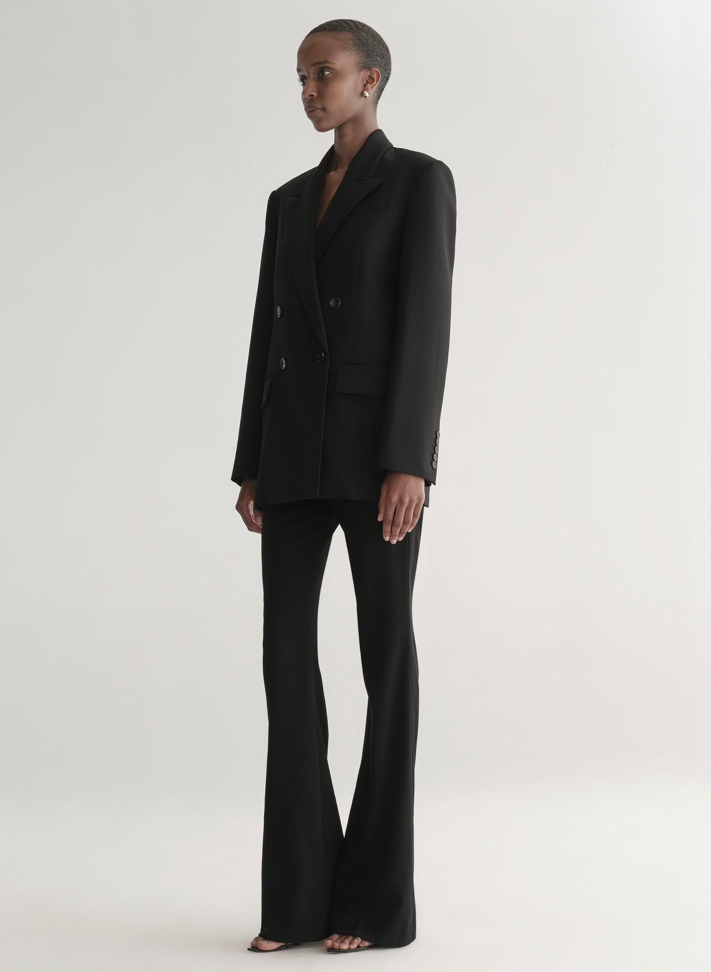 Person wearing a black suit on a white background