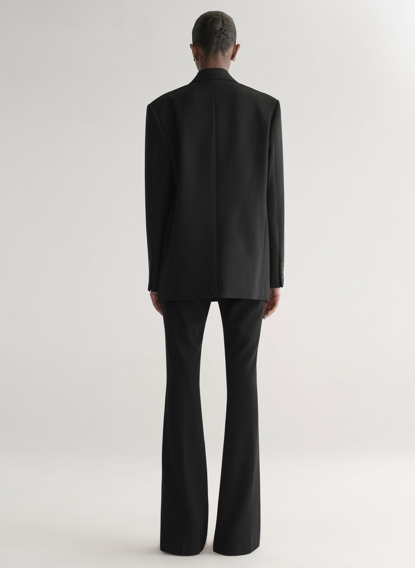 Person wearing a black suit on a white background