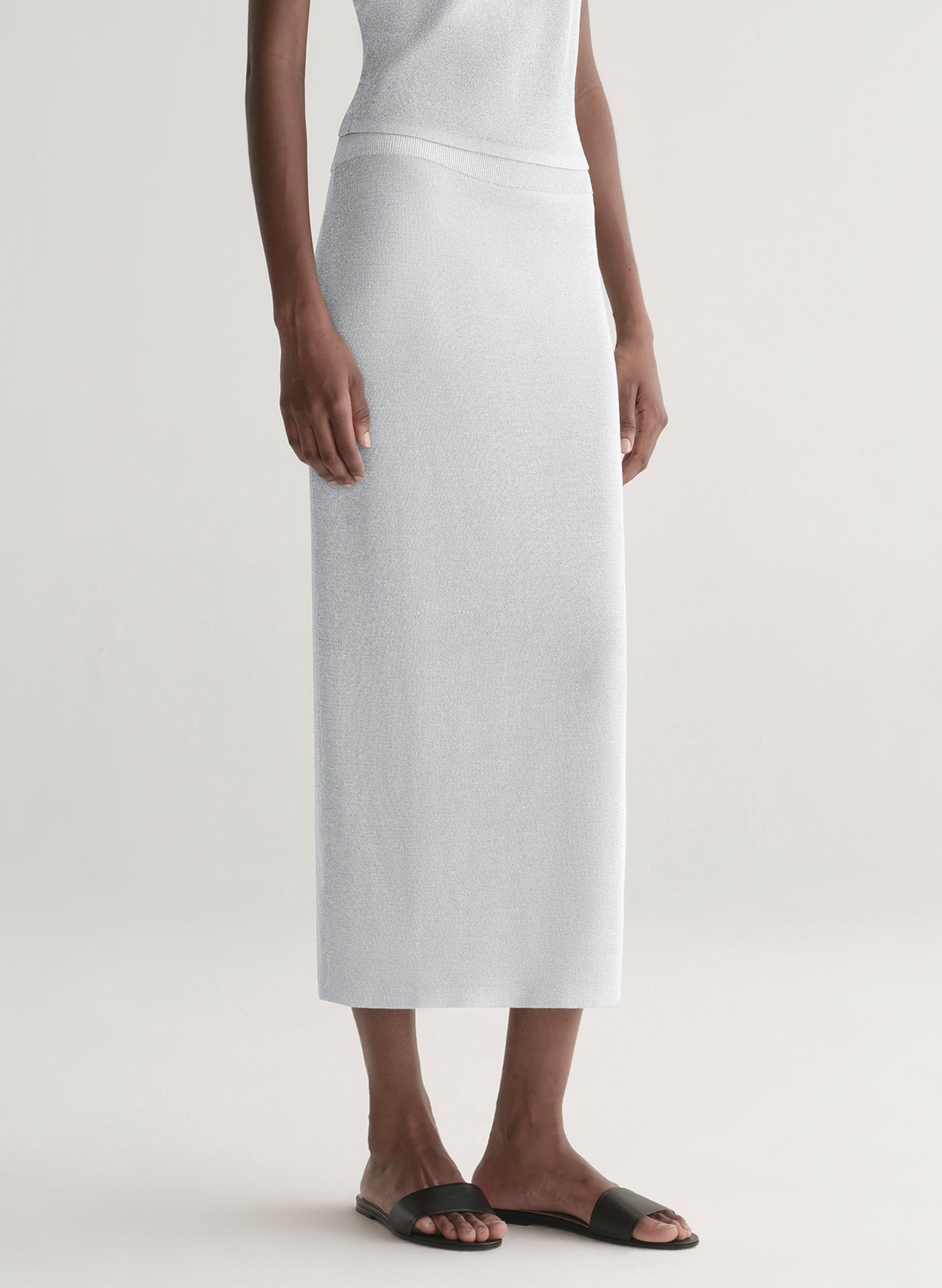 woman wearing silver one shoulder top and matching midi skirt