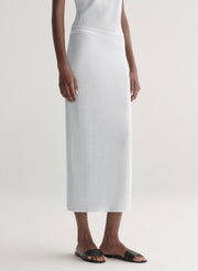 woman wearing silver one shoulder top and matching midi skirt