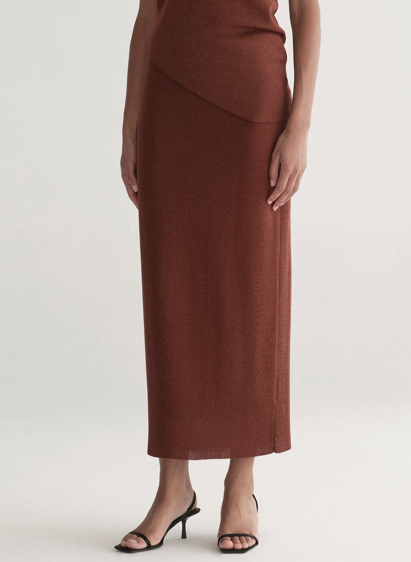 woman wearing rust knit top and skirt set