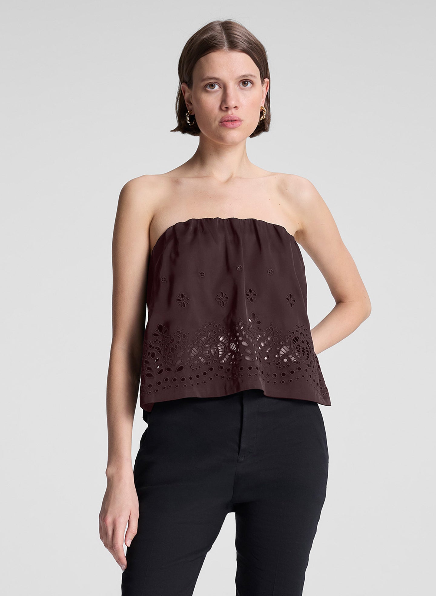 woman wearing dark brown strapless embroidered top with black capri pants