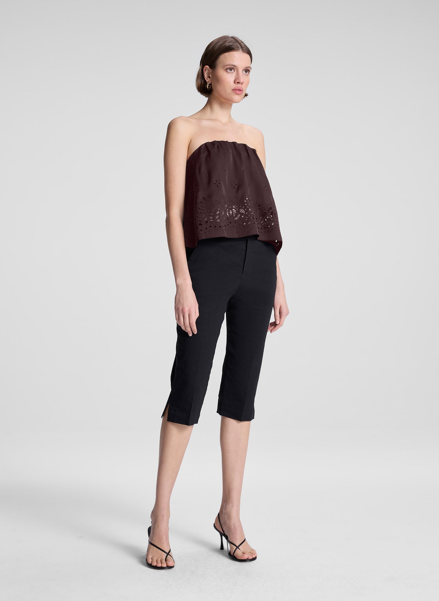 woman wearing dark brown strapless embroidered top with black capri pants