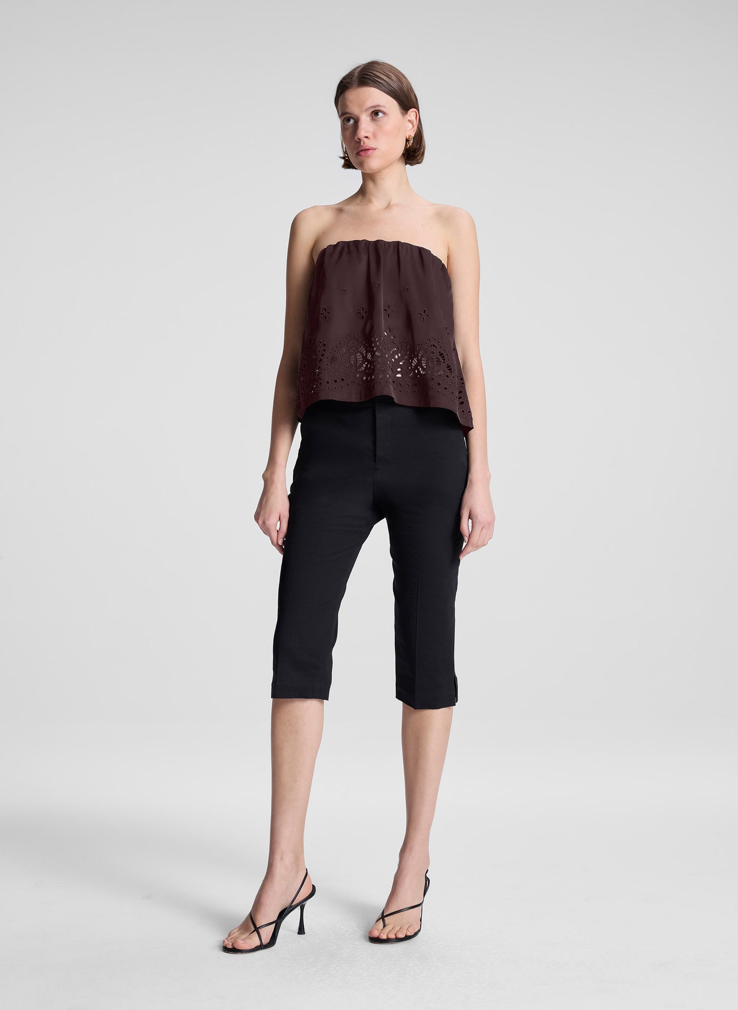 woman wearing dark brown strapless embroidered top with black capri pants