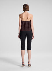woman wearing dark brown strapless embroidered top with black capri pants