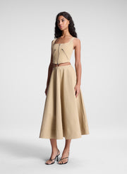 woman wearing beige zippered tank top and matching set beige midi skirt