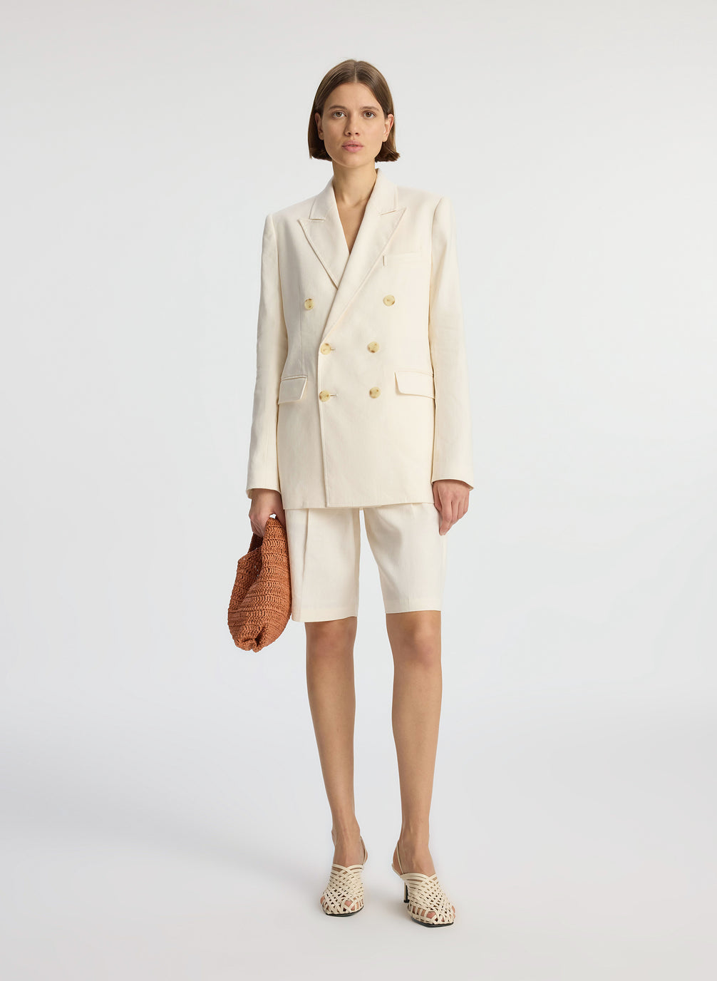 front view of woman wearing cream shorts suit