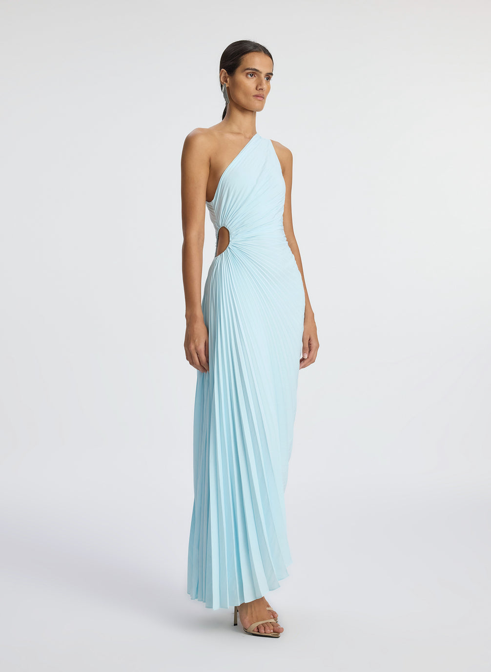 side  view of woman wearing aqua pleated one shoulder dress